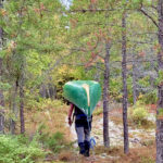 Liam man handling a canoe through the Temagami wilderness.